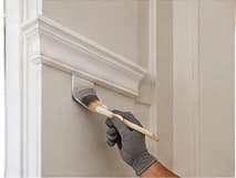 Painter working along interior trim and molding